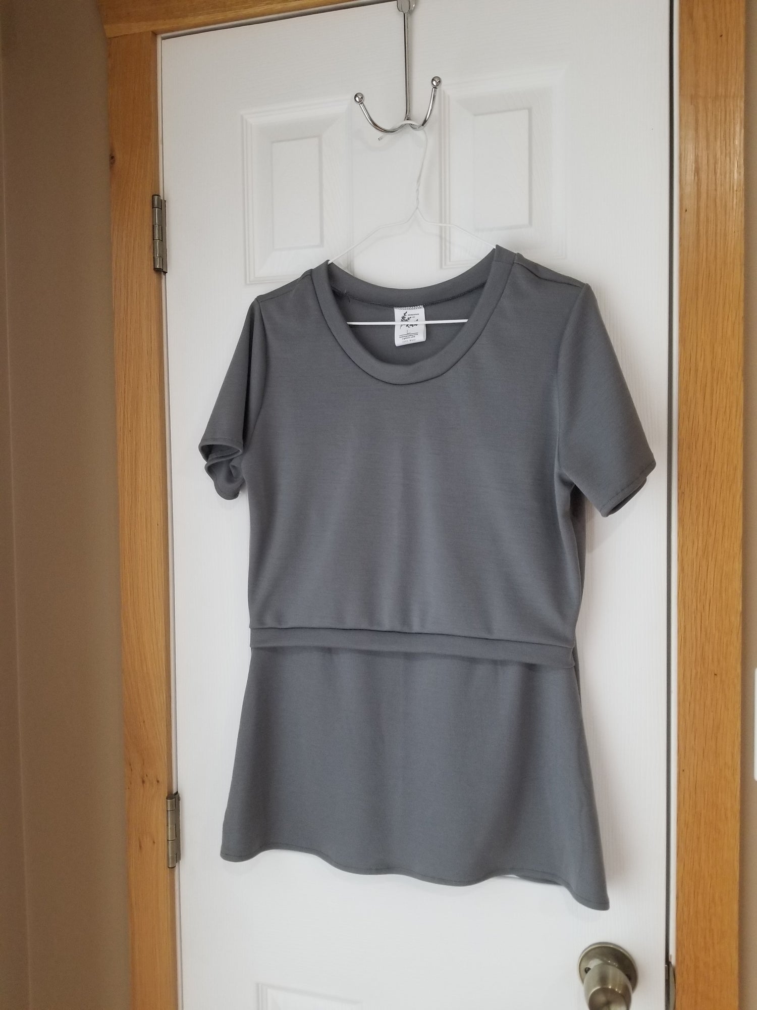 Grey, 100% Merino Wool Nursing / Breastfeeding Shirt hanging on a a hanger on a white door